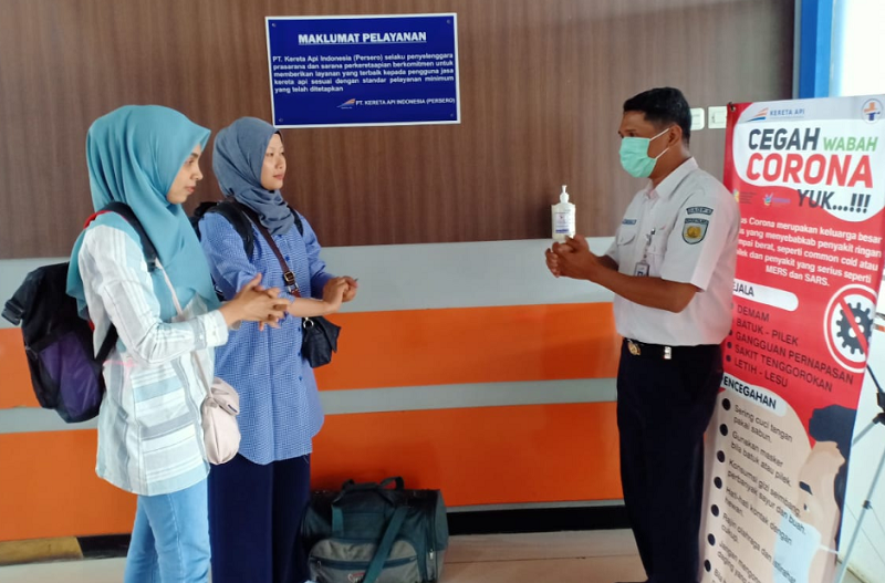 Petugas PT KAI bersama Pengguna Jasa Kereta Api Sedang menggunakan Hand Sanitizer