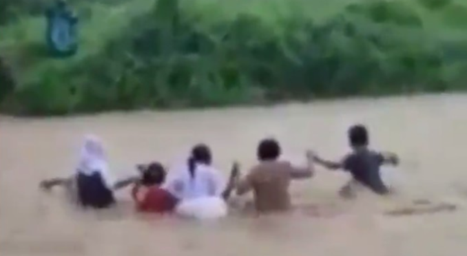Tangkapan layar video viral guru dan siswa di Malut seberangi sungai deras
