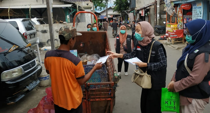 sejumlah relawan membagikan hygiene kit kepada pekerja lapangan yang terus bekerja karena ekonomi