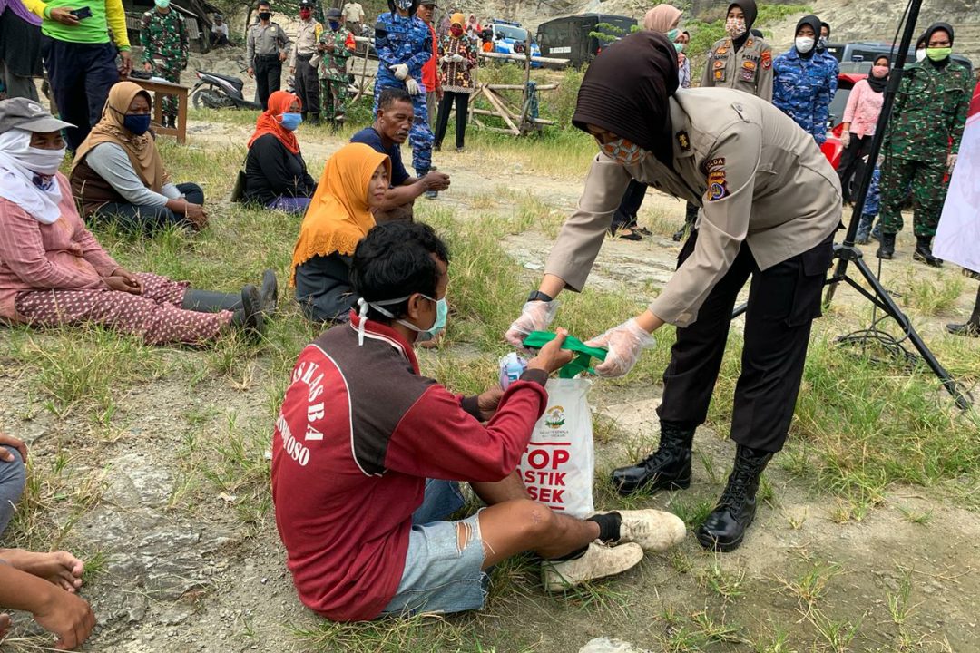 Seorang Polwan terlihat sedang membagikan sembako kepada penghuni TPST Piyungan. (Foto: Headline.co.id)