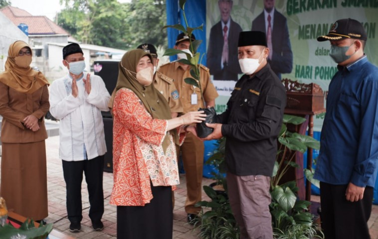 Kepala DLHK Kota Depok Ety Suryahatisaat menyerahkan secara simbolis bibit pohon kepada Ketua Kelompok Sadar Wisata Situ Cilodong