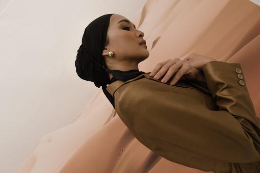 Desain jas bergaya edgy dipadupadankan dengan hijab hitam Bie Hin Tailor