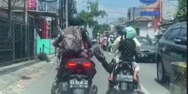 Tangkapan layar dari video seorang oknum anggota TNI yang menendang sepeda motor emak-emak di wilayah Jatiwarna