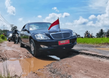 Mobil sedan yang dinaiki Presiden Joko Widodo terlihat melintasi Jalan Terusan Ryacudu, Kota Baru, Jati Agung, Lampung Selatan