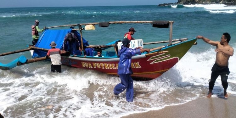 Nelayan di Pantai Sedahan sedang mengevakuasi korban terseret arus