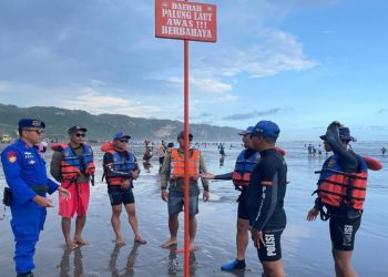 Petugas memasang rambu peringatan bahaya di kawasan Pantai Parangtritis untuk mencegah adanya laka laut