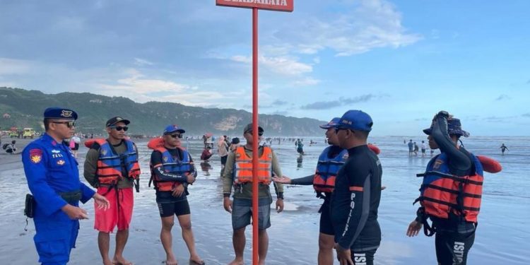 Petugas memasang rambu peringatan bahaya di kawasan Pantai Parangtritis untuk mencegah adanya laka laut