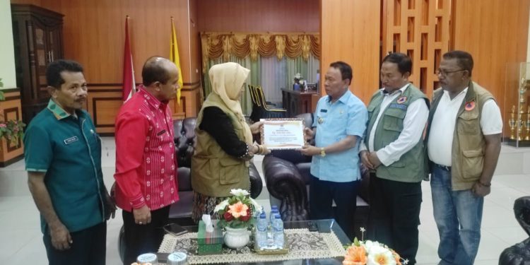 Direktur Pemulihan dan Peningkatan Sosial Ekonomi dan Sumber Daya Alam, Eny Supartini (baju hitam dengan rompi cokelat) menyerahkan bantuan berupa dana siap pakai kepada Pemerintah Kabupaten Kupang
