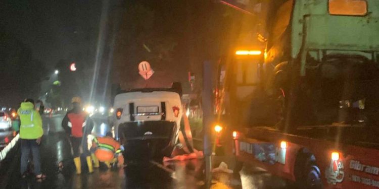 Tim Terkait Sedang Melakukan Evakuasi Mobil Mini Cooper Terbalik di perempatan Demak Ijo