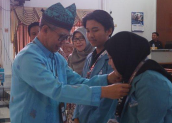 Pj Wali Kota Tegal, Dadang Somantri saat memakaikan identitas KKN tematik mahasiswa Universitas Alma Ata Yogyakarta di Adipura Balai Kota Tegal