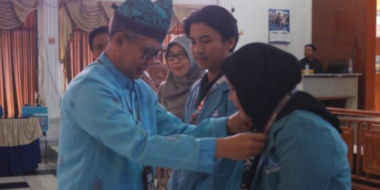 Pj Wali Kota Tegal, Dadang Somantri saat memakaikan identitas KKN tematik mahasiswa Universitas Alma Ata Yogyakarta di Adipura Balai Kota Tegal