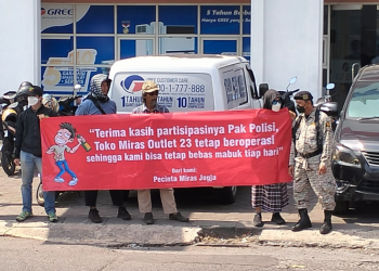 Peserta Orasi di Polda DIY sedang membentangkan sepanduk kritikan