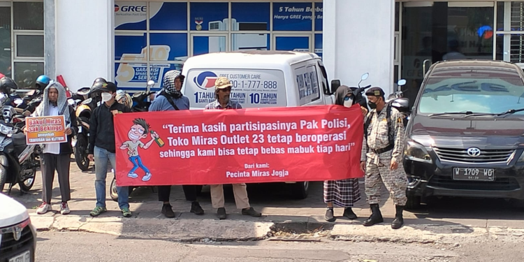 Peserta Orasi di Polda DIY sedang membentangkan sepanduk kritikan