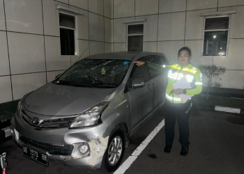 Petugas kepolisian menunjuk mobil Toyota Avanza yang Sempat menjadi sasaran amukan massa setelah terlibat dalam aksi tabrak lari di beberapa lokasi di Sleman