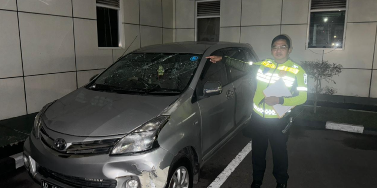 Petugas kepolisian menunjuk mobil Toyota Avanza yang Sempat menjadi sasaran amukan massa setelah terlibat dalam aksi tabrak lari di beberapa lokasi di Sleman