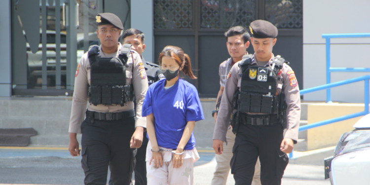 Polisi mengawal pelaku pencurian laptop yang berhasil ditangkap oleh Unit Reskrim Polsek Sewon setelah teridentifikasi melalui rekaman CCTV di sebuah minimarket di Bantul