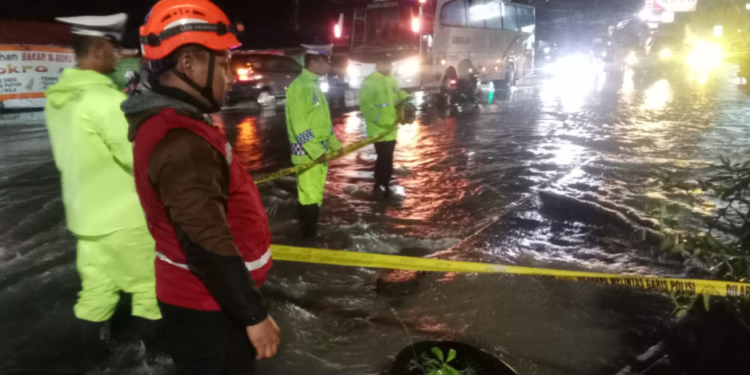 Petugas Kepolisian memasang Police line di lokasi kejadian