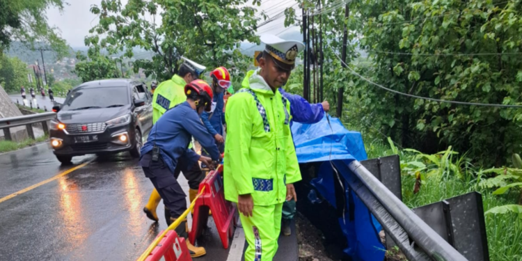 Petugas kepolisian bersama tim terkait memasang water barrier dan penanda peringatan di lokasi tanah longsor Jalan Nasional Jogja-Wonosari Km 15, Dusun Plesedan, Kalurahan Srimulyo, Piyungan, Bantul