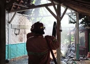 Petugas pemadam sedang memadamkan api