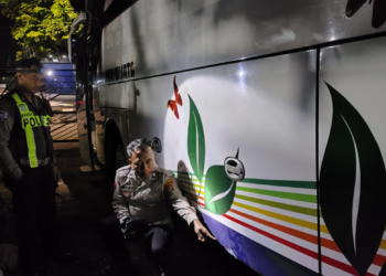 Polisi melakukan pemeriksaan pada bagian samping bus yang terlibat kecelakaan di simpang empat Wojo, Bangunharjo, Sewon, Bantul