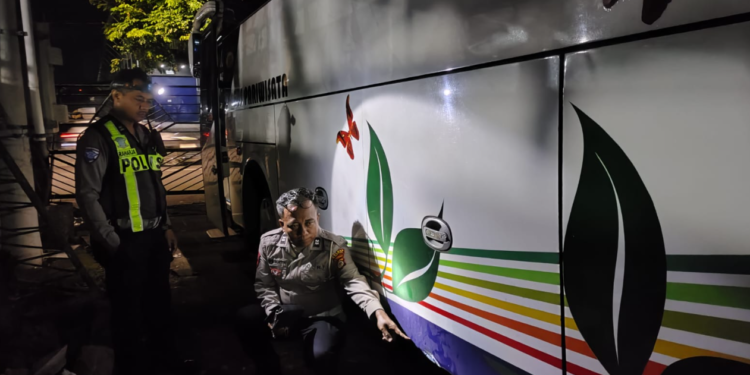 Polisi melakukan pemeriksaan pada bagian samping bus yang terlibat kecelakaan di simpang empat Wojo, Bangunharjo, Sewon, Bantul