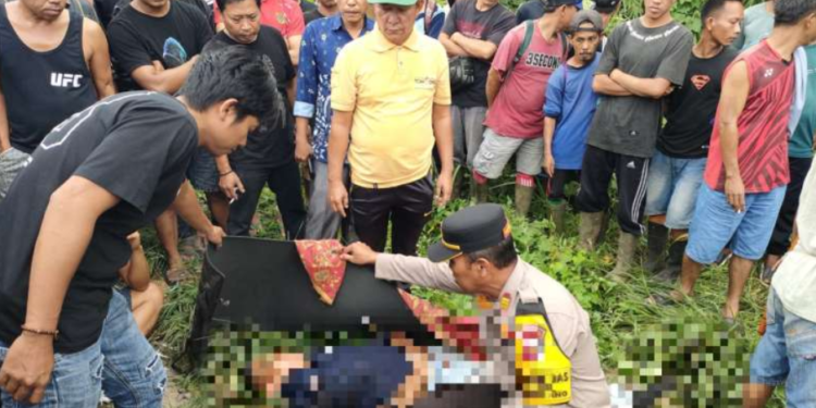 Anggota polisi bersama warga sekitar saat mengevakuasi jasad korban yang dìtemukan tewas penuh luka tusukan