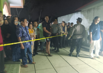 Petugas memasang garis polisi di tempat penemuan jasad warga yang meninggal dunia di tempat wudhu masjid