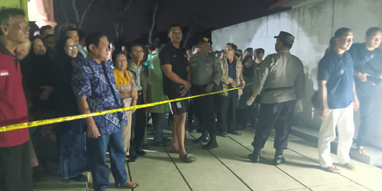 Petugas memasang garis polisi di tempat penemuan jasad warga yang meninggal dunia di tempat wudhu masjid