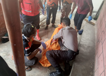 Petugas kepolisian bersama tim medis mengevakuasi jenazah seorang pria yang ditemukan meninggal di teras rumah di kawasan Patehan, Kraton, Yogyakarta