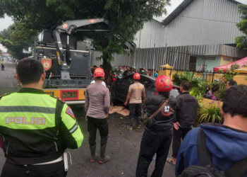 Polisi dan tim evakuasi mengangkat mobil yang menabrak dua motor dan pohon di Wiyoro, Banguntapan