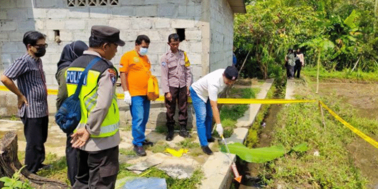 Petugas kepolisian bersama tim Inafis dan warga melakukan olah tempat kejadian perkara (TKP) di lokasi penemuan jasad bayi perempuan di parit pinggir sawah
