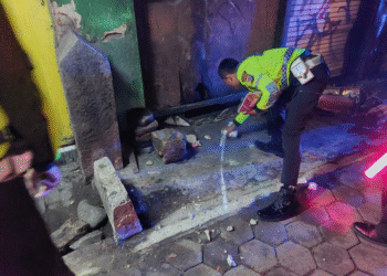 Seorang petugas kepolisian dari Unit Gakkum Satlantas Polresta Sleman tengah melakukan olah tempat kejadian perkara (TKP) kecelakaan lalu lintas yang terjadi di Simpang Tiga Ringroad,