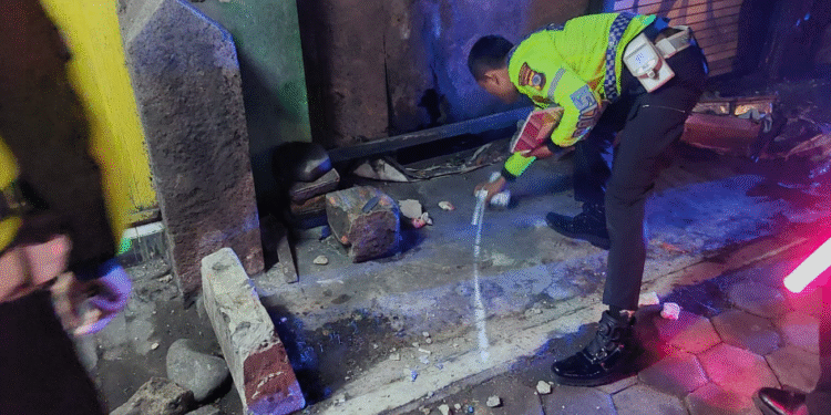 Seorang petugas kepolisian dari Unit Gakkum Satlantas Polresta Sleman tengah melakukan olah tempat kejadian perkara (TKP) kecelakaan lalu lintas yang terjadi di Simpang Tiga Ringroad,