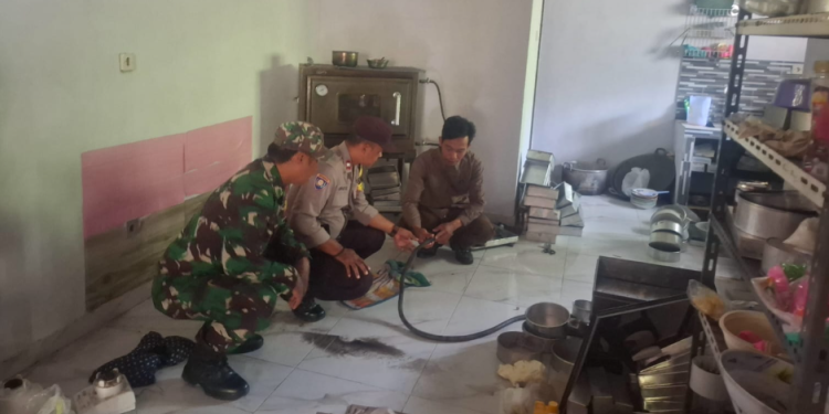 Petugas Bhabinkamtibmas, Babinsa, dan relawan tengah memeriksa selang tabung gas di lokasi kebakaran akibat kebocoran gas melon di Dusun Kemloko, Srimartani, Piyungan, Bantul