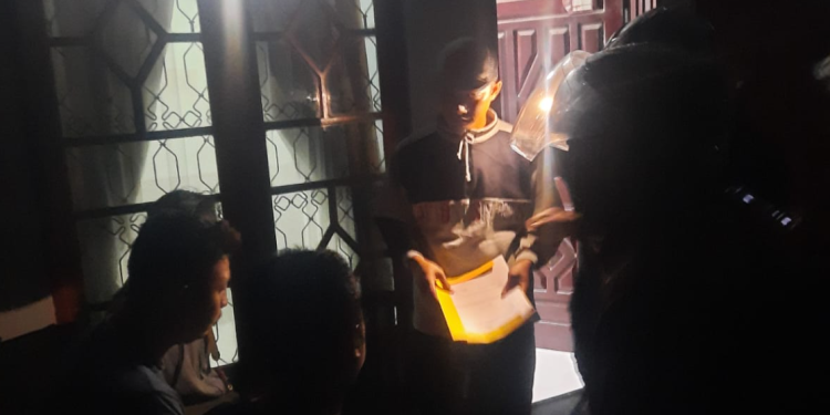 Petugas kepolisian menunjukkan surat penangkapan kepada terduga pelaku jambret kalung emas saat operasi penangkapan di wilayah Brosot, Galur