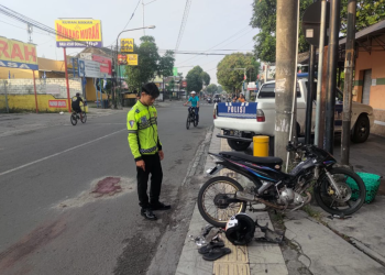 Seorang petugas kepolisian tengah memeriksa lokasi kecelakaan di Jalan Pramuka, depan RM Padang Giwangan, Umbulharjo, Yogyakarta