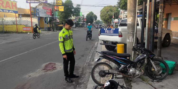 Seorang petugas kepolisian tengah memeriksa lokasi kecelakaan di Jalan Pramuka, depan RM Padang Giwangan, Umbulharjo, Yogyakarta