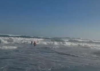 Petugas rescue Satlinmas Wilayah III Parangtritis berenang ke tengah laut untuk menyelamatkan wisatawan yang terseret ombak