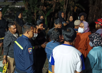 Warga bersama petugas kepolisian dan tenaga medis berkumpul di lokasi kejadian penemuan seorang pekerja proyek yang meninggal mendadak di Dusun Gatak, Tamantirto, Kasihan, Bantul