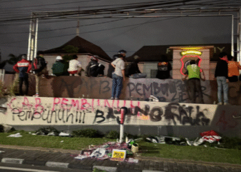 Coretan bernada protes terpampang di pagar Polda DIY usai massa aksi melakukan vandalisme