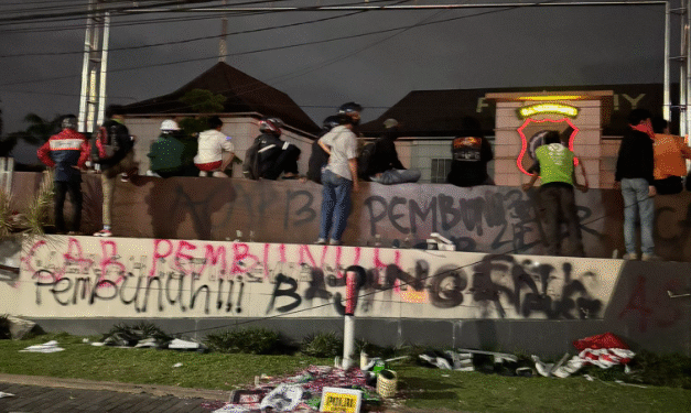 Coretan bernada protes terpampang di pagar Polda DIY usai massa aksi melakukan vandalisme