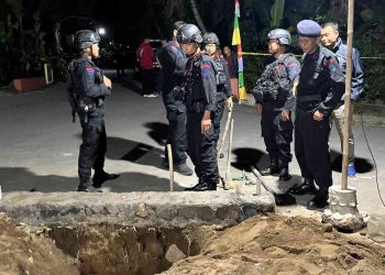Petugas Jibom Gegana Brimob Polda DIY bersama Polsek setempat berjaga di lokasi penemuan benda diduga peluru mortir di Dusun Tanjung, Umbulmartani, Ngemplak, Sleman