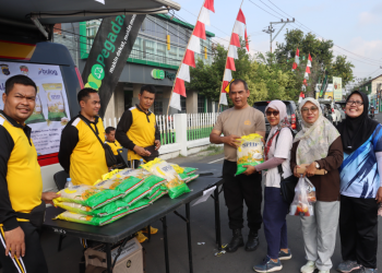 Petugas Satgas Pangan Polres Bantul membagikan beras Stabilisasi Pasokan dan Harga Pangan (SPHP) kepada warga dalam kegiatan Gerakan Pangan Murah saat car free day di Lapangan Paseban Bantul