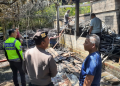 Petugas kepolisian bersama warga meninjau lokasi gudang perkakas yang terbakar di Dusun Gatak Klegung, Donokerto, Turi, Sleman