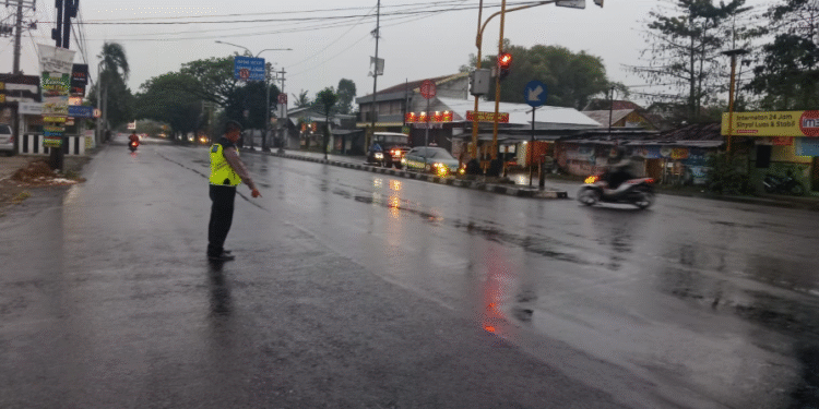 Petugas kepolisian menunjukan lokasi terjadinya kecelakaan dua sepeda motor di simpang empat Tamantirto, Kasihan, Bantul