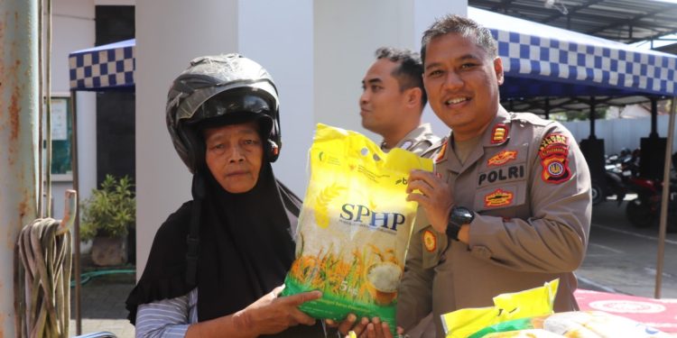 Polisi menyerahkan beras SPHP kepada warga dalam kegiatan Gerakan Pangan Murah di halaman Kantor Dinas Ketahanan Pangan dan Pertanian Kabupaten Bantul