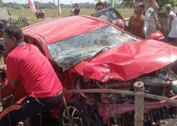 Warga Membantu mengevakuasi mobil yang ringsek usai tertabrak KA Batara Kresna di perlintasan sebidang wilayah Pasarnguter-Wonogiri