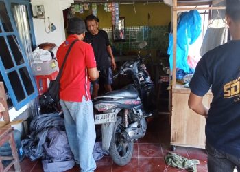 Warga menunjukkan sepeda motor dan selimut mobil yang terbakar akibat pelemparan botol berisi bensin bersumbu di rumah korban di Dusun Mojosari, Sitimulyo, Piyungan, Bantul