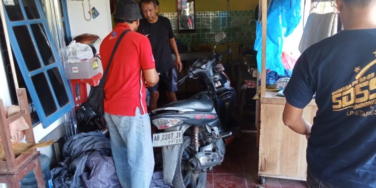 Warga menunjukkan sepeda motor dan selimut mobil yang terbakar akibat pelemparan botol berisi bensin bersumbu di rumah korban di Dusun Mojosari, Sitimulyo, Piyungan, Bantul