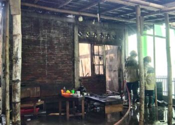 Petugas BPBD Bantul memadamkan sisa api di rumah milik Endra Yulio Pratama di Dusun Paten, Sumberagung, Jetis, Bantul